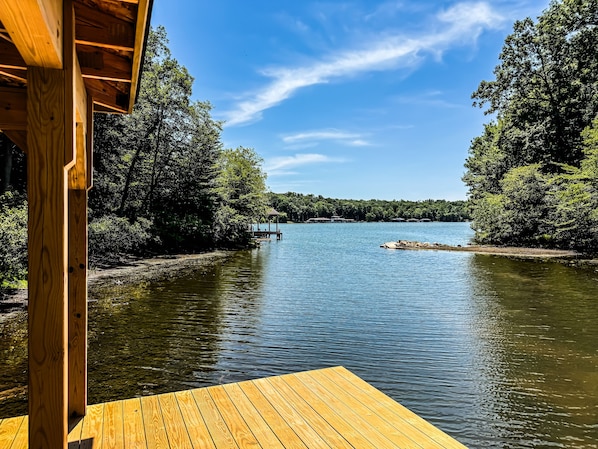 A wooden deck extending over a calm lake with dense trees on both sides. - Lakewood | NEW Lake Anna Luxury Retreat (Spotsylvania Courthouse)