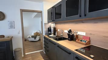 Una cocina moderna con armarios oscuros, una encimera de madera y una cocina negra.