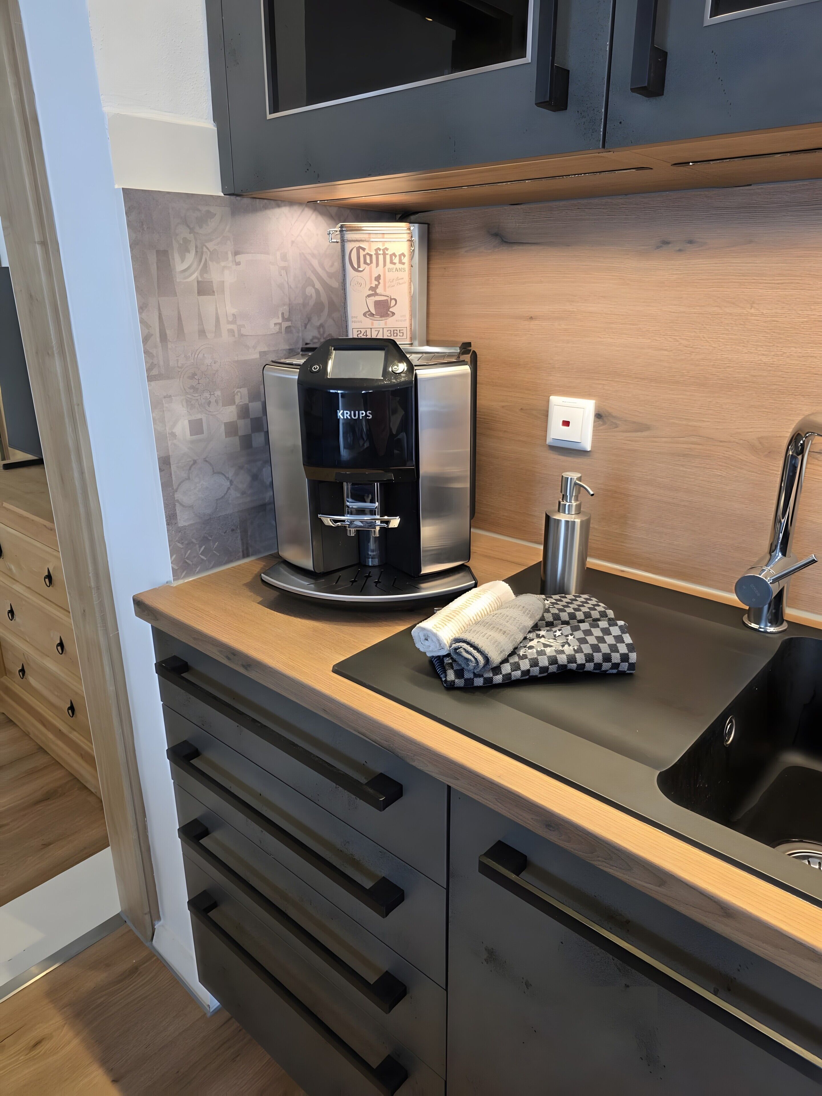 Eine moderne Küche mit Kaffeemaschine, Spüle und einem Handtuch auf der Arbeitsfläche.