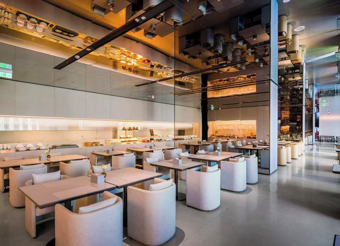 A modern restaurant interior with tables and chairs, a kitchen area, and a bar.