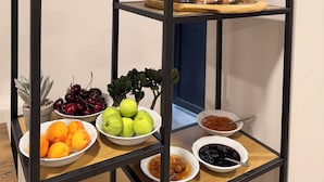 Estante metálica em vários níveis com diversos alimentos, plantas e objetos decorativos.