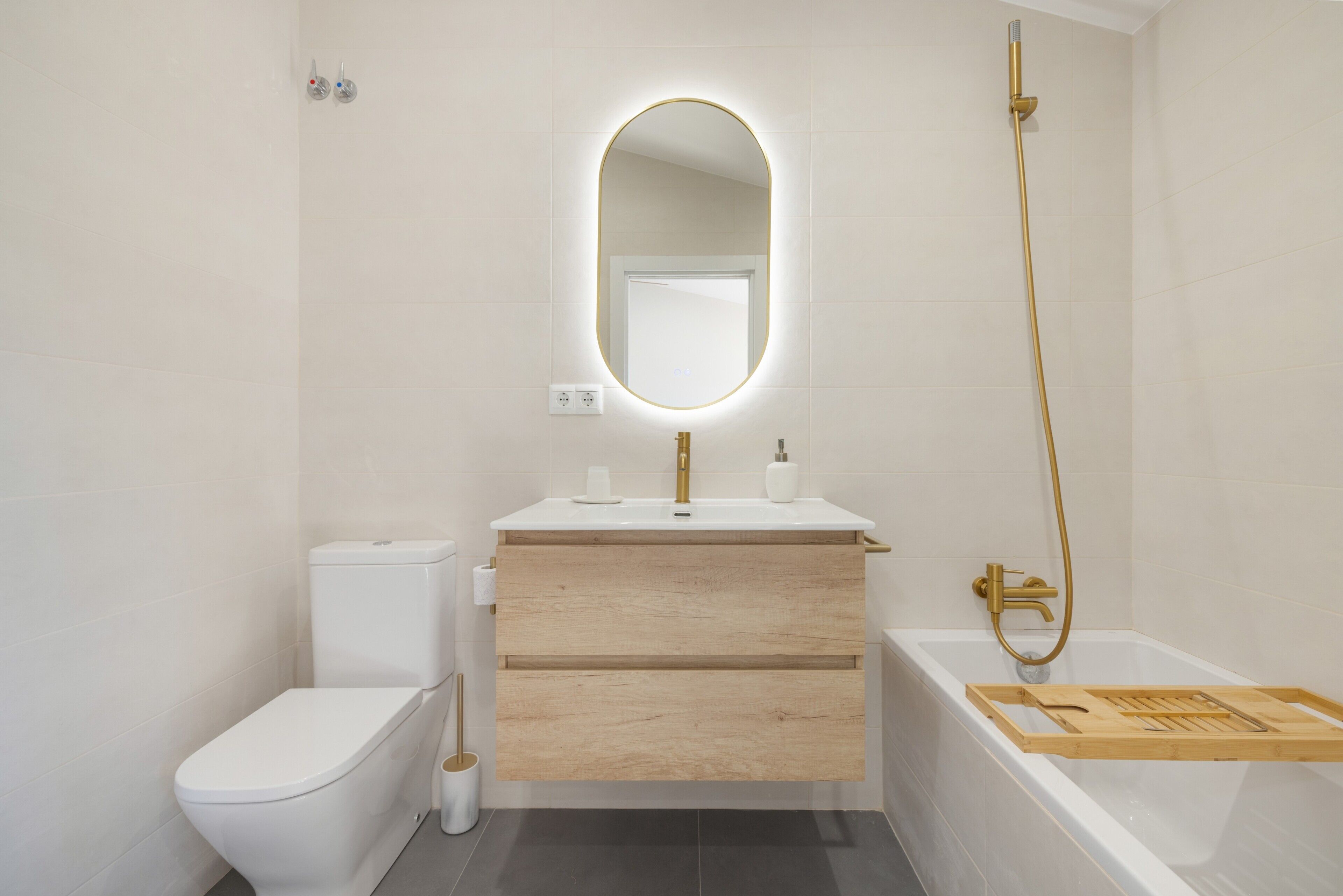 Een moderne badkamer met toilet, wastafel en bad.
