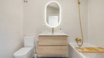Een moderne badkamer met toilet, wastafel en bad.
