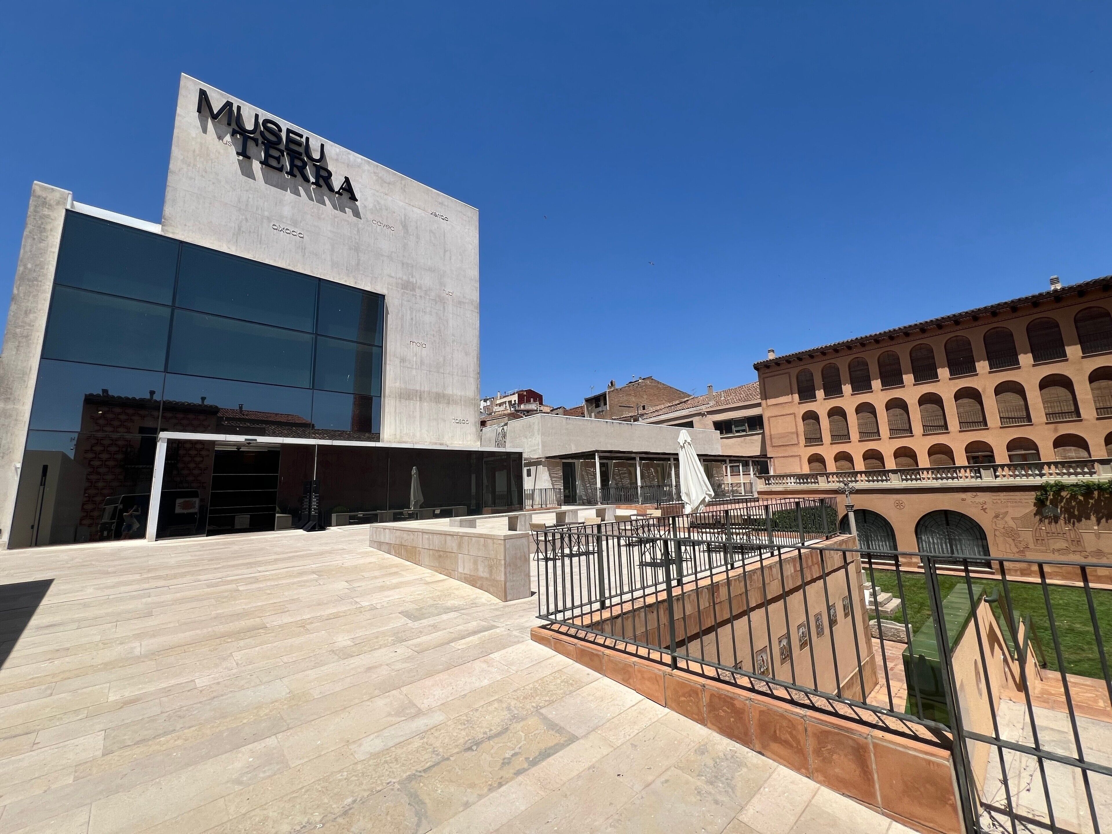 A modern building with a large glass facade and a sign reading 'MUSEU TERRÀ'.