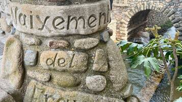 En stenkupol med inristad text, en stenbro och en fontän.