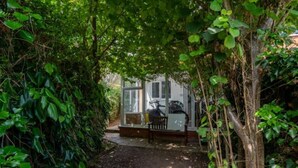 A pathway leading to a covered outdoor seating area with a bicycle parked nearby. - Peaceful Cambridge haven - walk to Addenbrookes (Cambridgeshire)