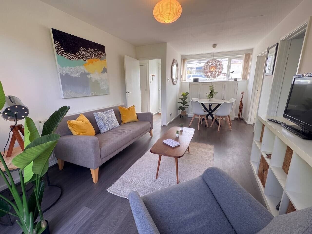 A modern living room with a sofa, coffee table, and TV stand.