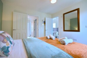 Una habitación de hotel con cama, baño y espejo.