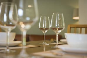 Een eettafel met wijnglazen en kommen, doet denken aan een restaurant.
