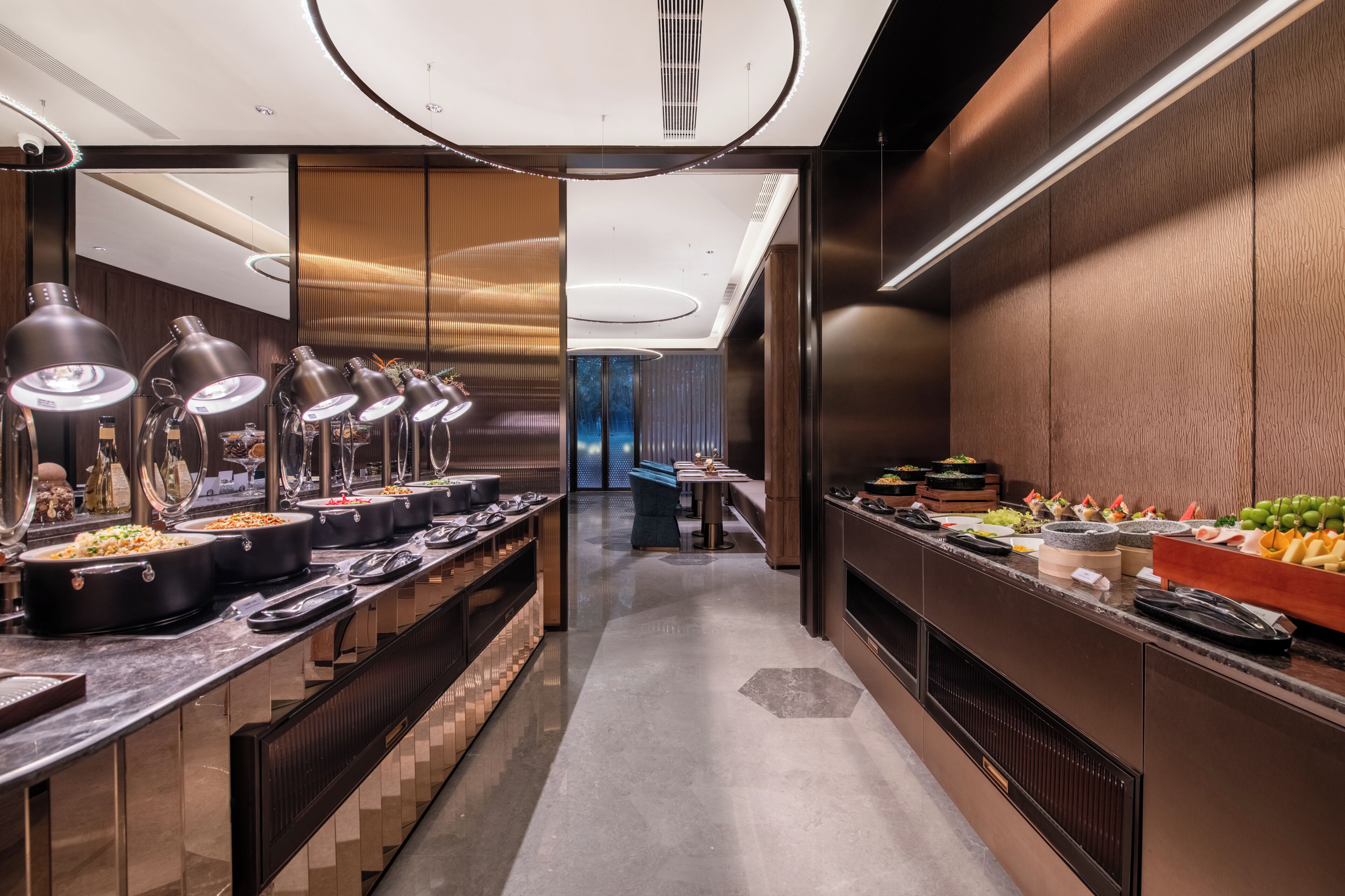 Een moderne buffetopstelling met meerdere bedieningspunten, een centraal zitgedeelte en een eigentijds interieur.