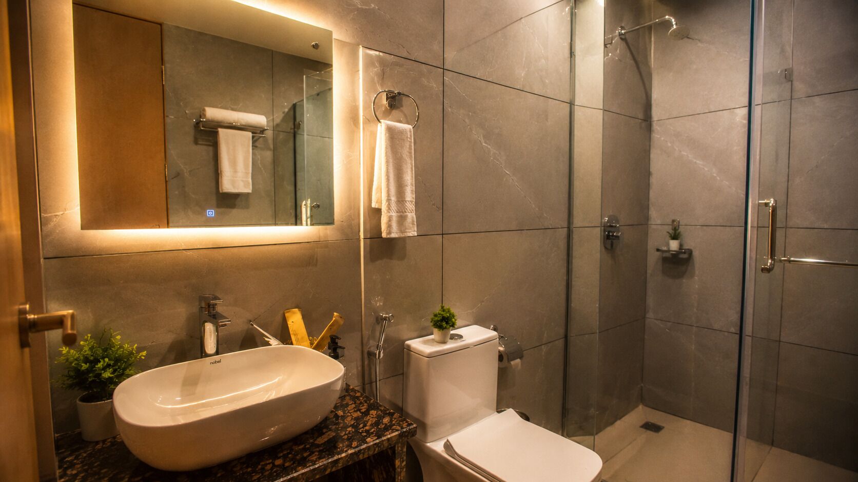 A modern bathroom with a large sink, toilet, and shower.