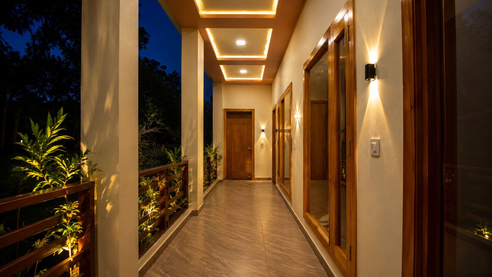 A well-lit corridor with wooden doors and a tiled floor, leading to a room.