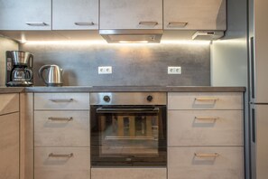 Eine Küche mit Edelstahlgeräten, darunter eine Kaffeemaschine und ein Backofen.