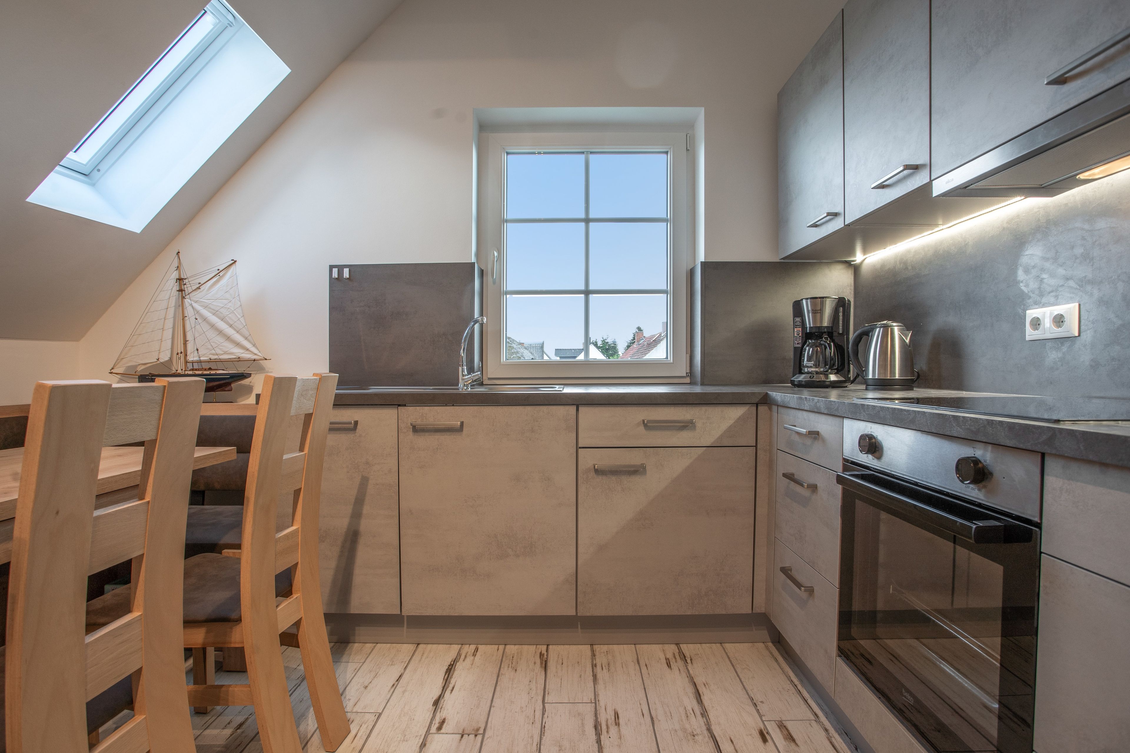 Una cocina moderna con tragaluces, cafetera y hervidor sobre la encimera.