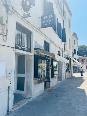 Edifici amb un rètol que diu 'Hotel Airone' i una botiga anomenada 'Mira'.