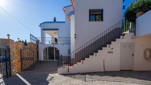 A two-story building with a staircase, a gate, and a paved courtyard. - Villa “Paraiso” with Sea View, Wi-Fi, and Air Conditioning (Calp)