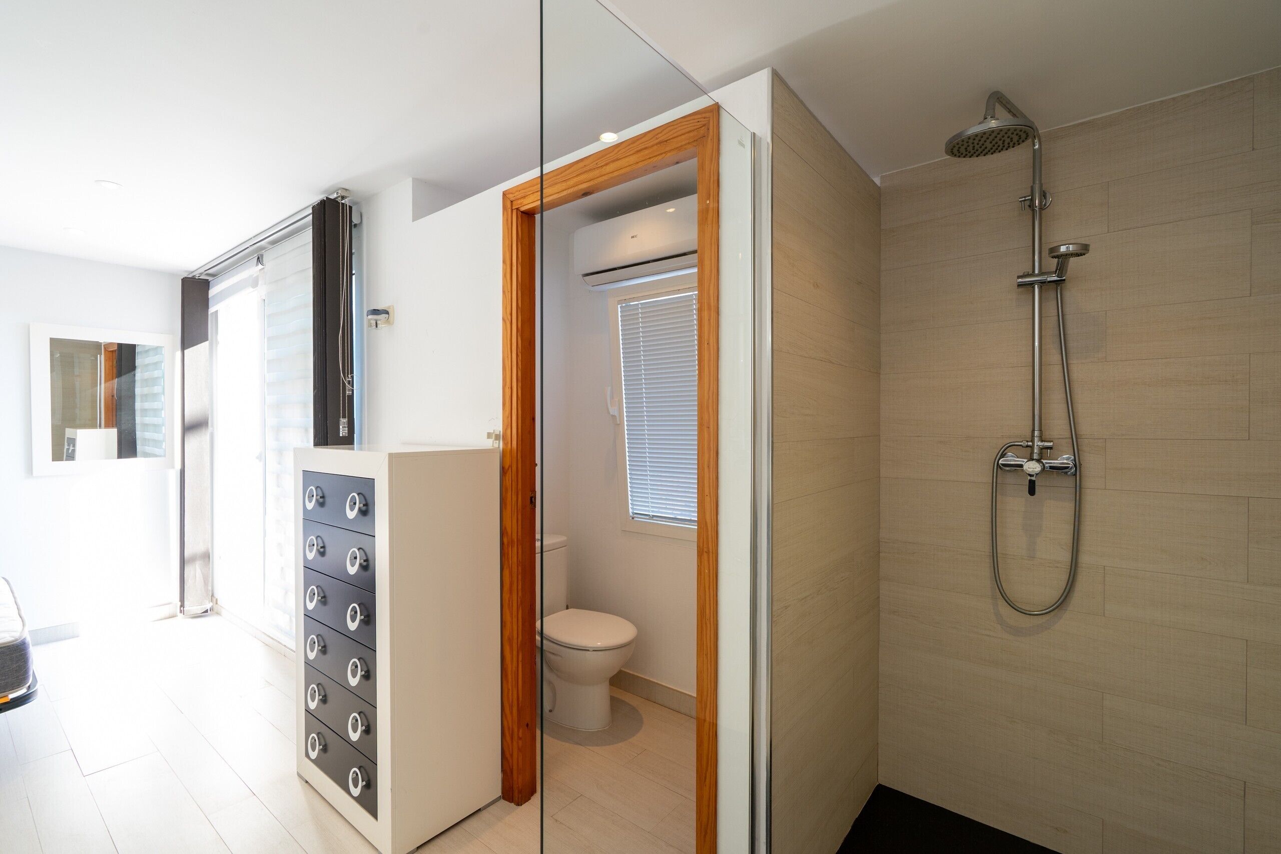 Ein modernes Badezimmer mit Dusche, Toilette und einer Glasabtrennung.