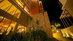 A modern building with a red roof, large windows, and outdoor plants. - Abhyagama Hotel (Digha)