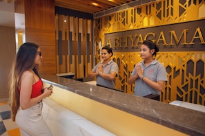 A reception desk with a wooden panel design and the name 'ABHYACAMA' in gold letters. - Abhyagama Hotel (Digha)