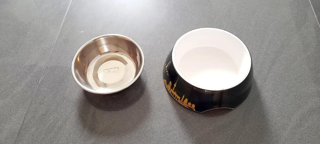 Two bowls, one metallic and one ceramic, on a dark surface.