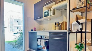 Une cuisine moderne équipée d’un four encastré, d’un évier et d’un plan de travail sur lequel sont disposés divers objets.