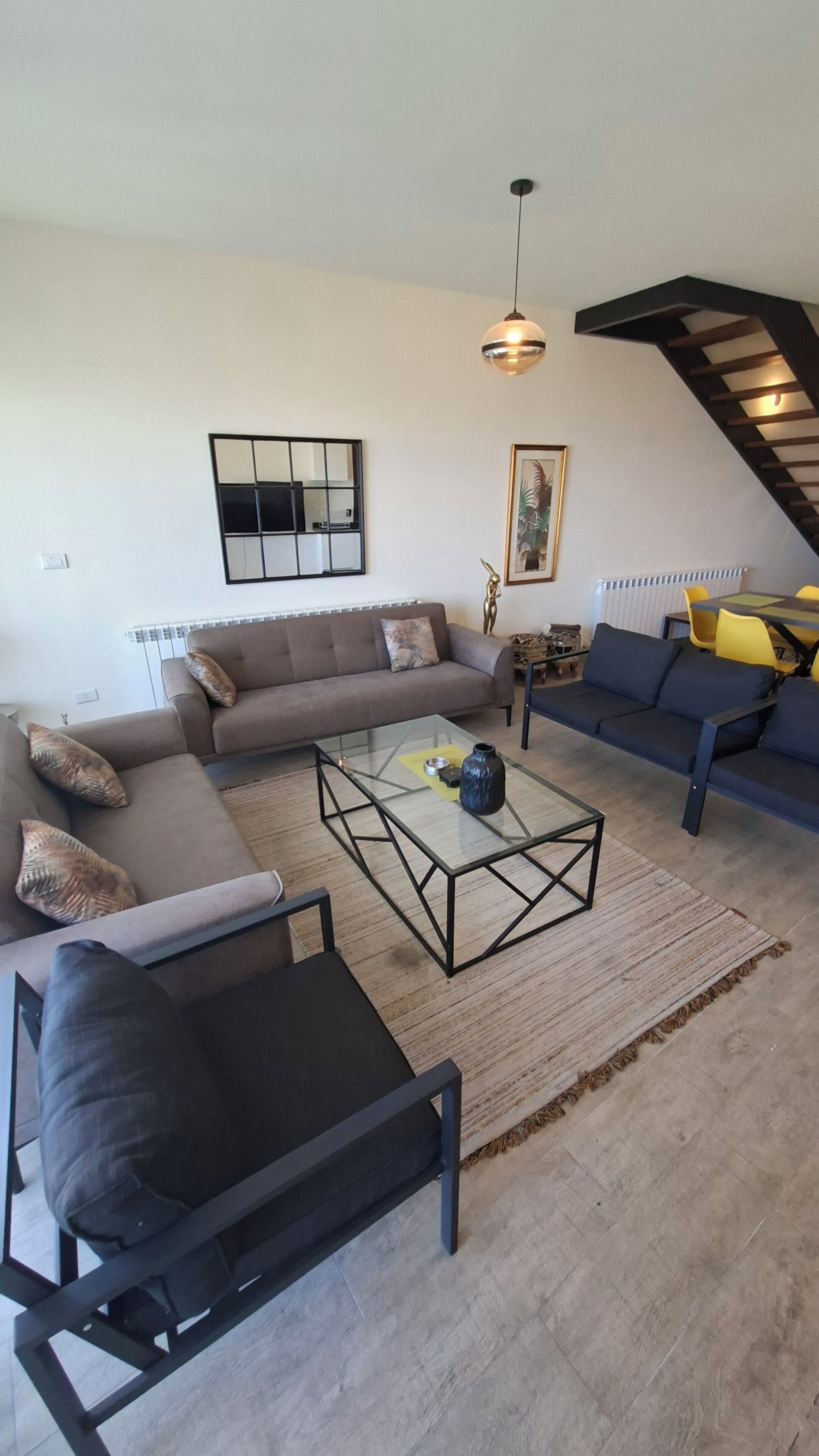 Un salon comprenant un canapé, une table basse et un coin repas avec des chaises.