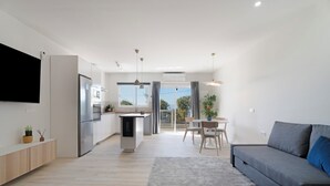 Un apartament modern amb cuina, zona de menjador i saló.