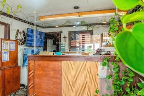 Una zona de recepción con un escritorio de madera, una bandera estadounidense y una cruz en la pared.