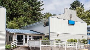 A building with a porch, a staircase, and a fenced area. - Full Bed Non-Smoking (Stevenson WA)