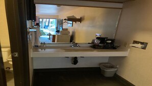 A bathroom with a sink, mirror, and a small trash bin. - 2 Full Beds | Non-Smoking (Stevenson WA)