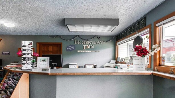 A reception desk with a sign for Rodeway Inn, a business center, and a window with a view. - 2 Full Beds | Non-Smoking (Stevenson WA)