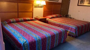 A hotel room with two beds, a nightstand, a lamp, and a door. - 2 Full Beds | Non-Smoking (Stevenson WA)