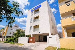 A 10b hotels building with a white facade, multiple balconies, and a gated entrance. - Fabhotel Nimalan Residency Sholinganallur (Chennai)