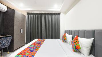 A hotel room with a bed, a desk, and a chair.