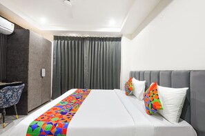 Una habitación de hotel con cama, escritorio y una silla.