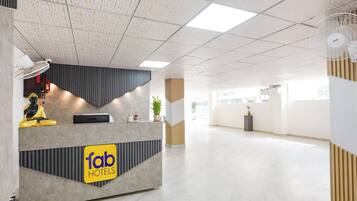 A hotel reception area with a modern design, a reception desk, and a statue.