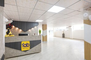 Zona de recepción de un hotel de diseño moderno, con mostrador de recepción y una estatua.