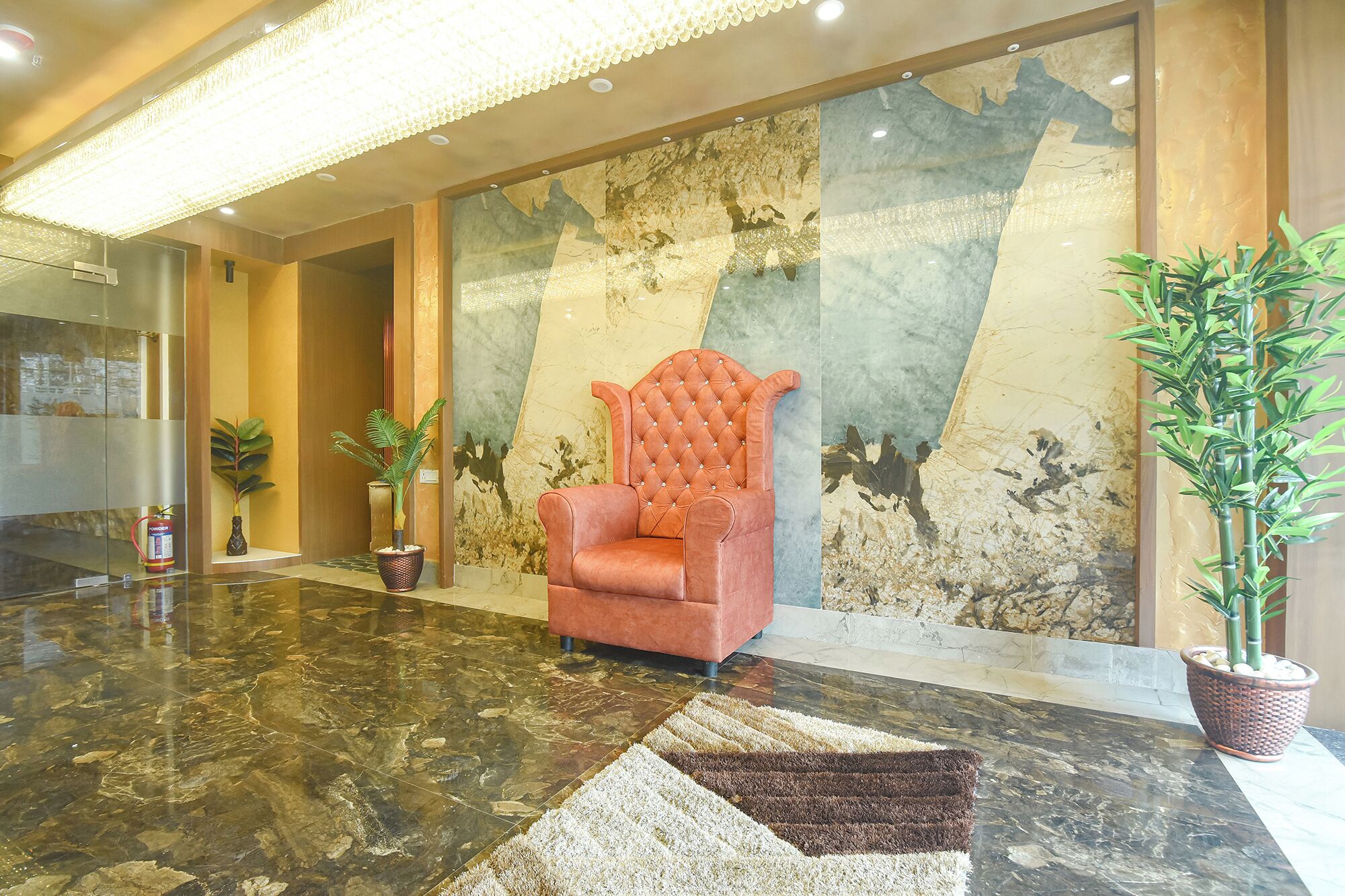A lobby with a plush armchair, a marble floor, and a large wall with a map.