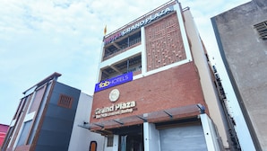 Un hotel llamado 'Grand Plaza' con un cartel que indica 'Tab Hotels' y 'Habitaciones, Restaurante, Terraza'.