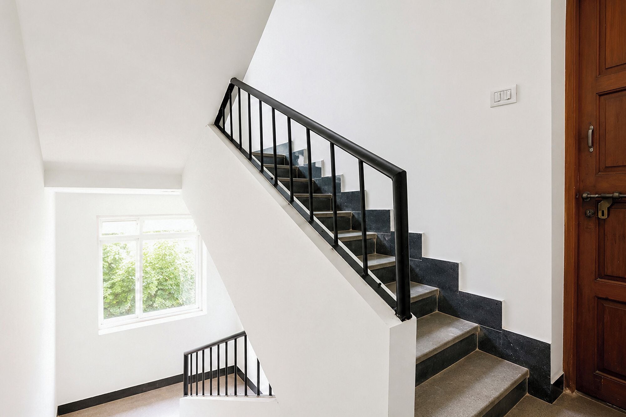 A staircase with black railings leading to a landing.