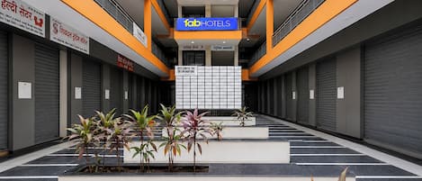 Interior moderno de un hotel con un atrio central, un ascensor visible y un letrero que dice '1abHOTELS'.