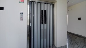 Puerta de ascensor con panel de control y señal que indica su uso en caso de incendio.