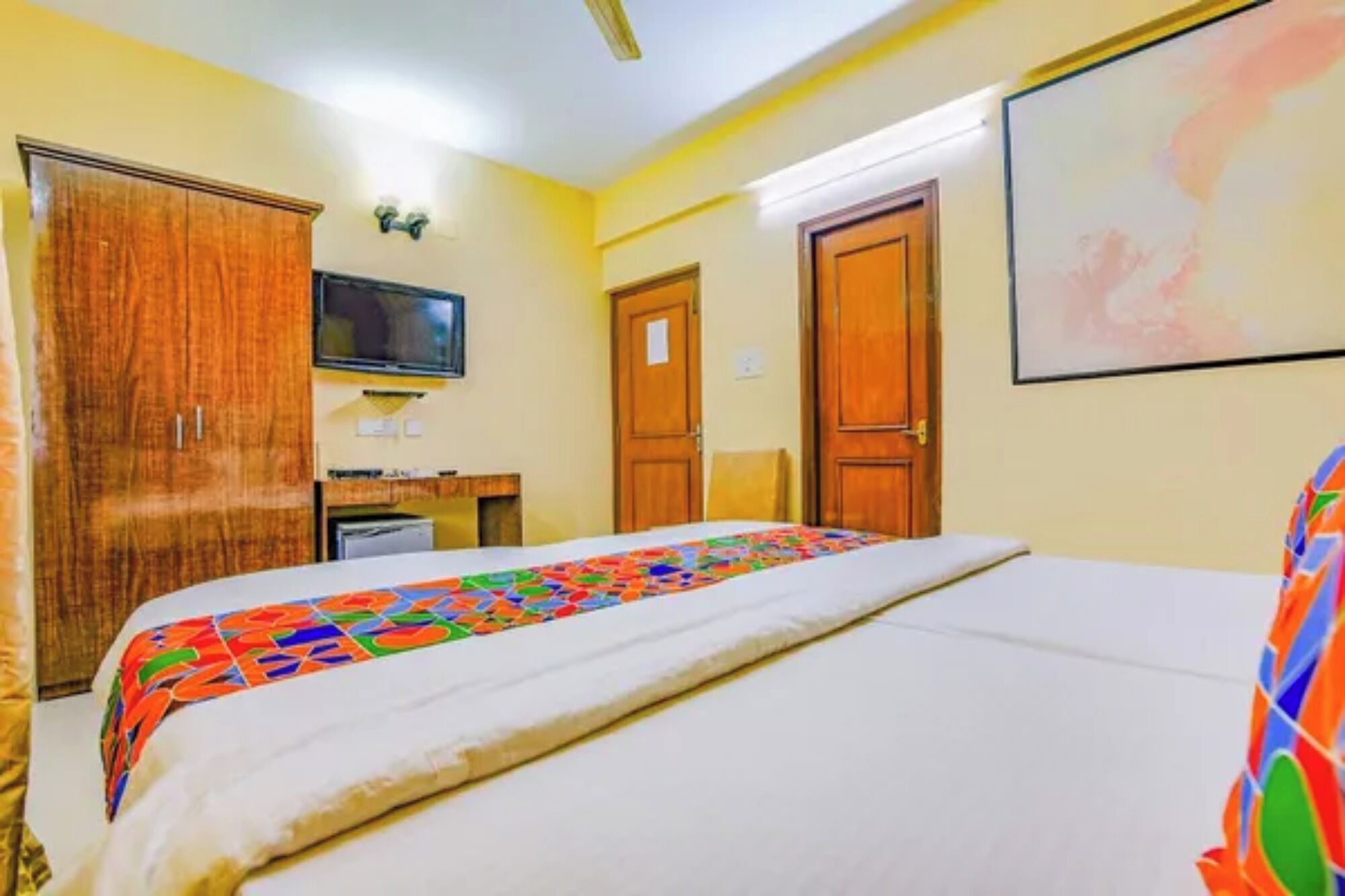 Une chambre d’hôtel équipée d’un lit, d’une télévision, d’un bureau et d’une armoire.