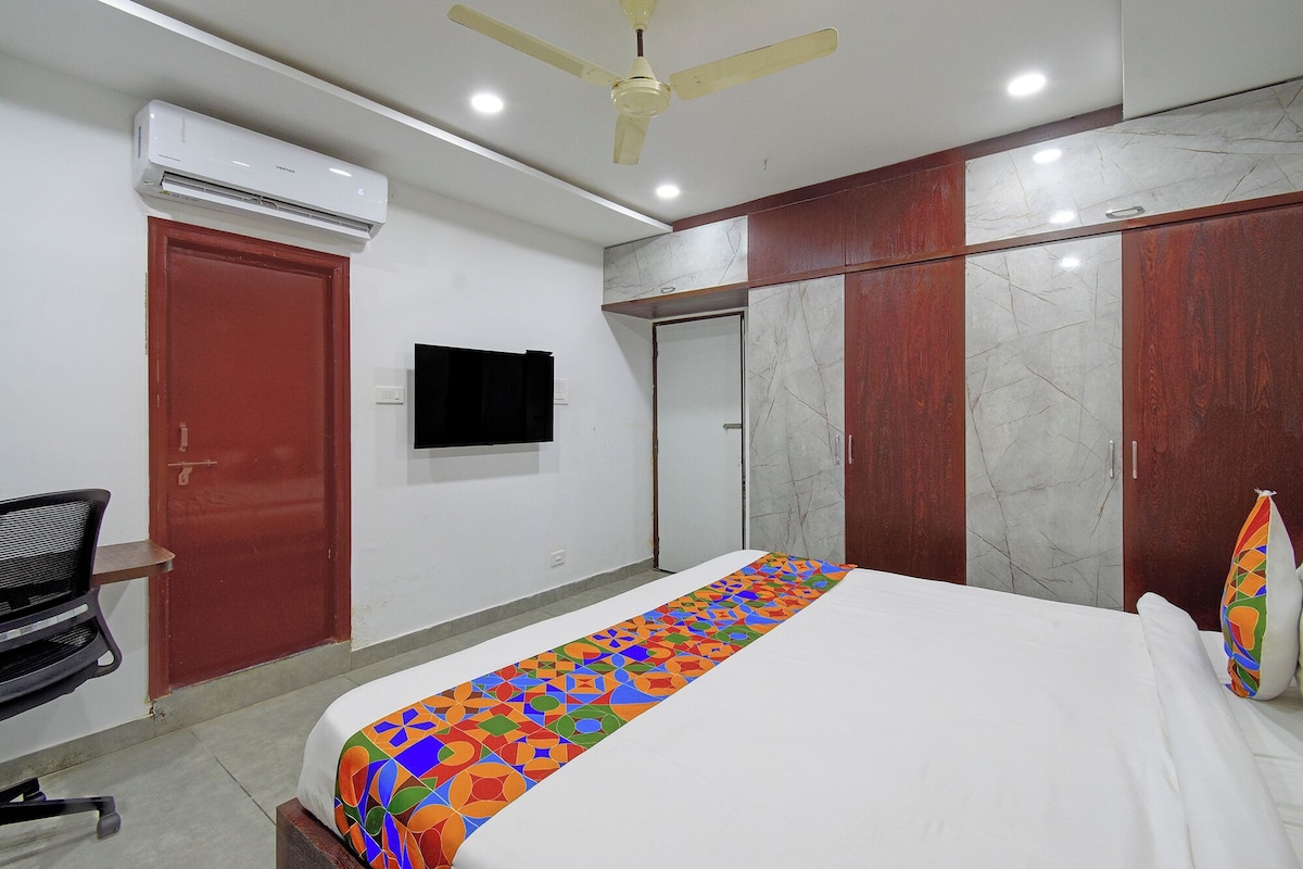 Un dormitorio con cama, escritorio, silla, televisor y armario.