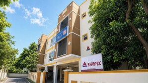 Un edificio de varios pisos con un letrero que dice 'SKYPIX' y una entrada con portones.