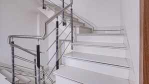 A white staircase with metal handrails and a wooden door frame.