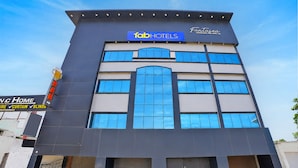 Un edificio de varios pisos con un letrero de 'fabHOTELS' y un letrero de 'FantaSea' sobre la entrada.