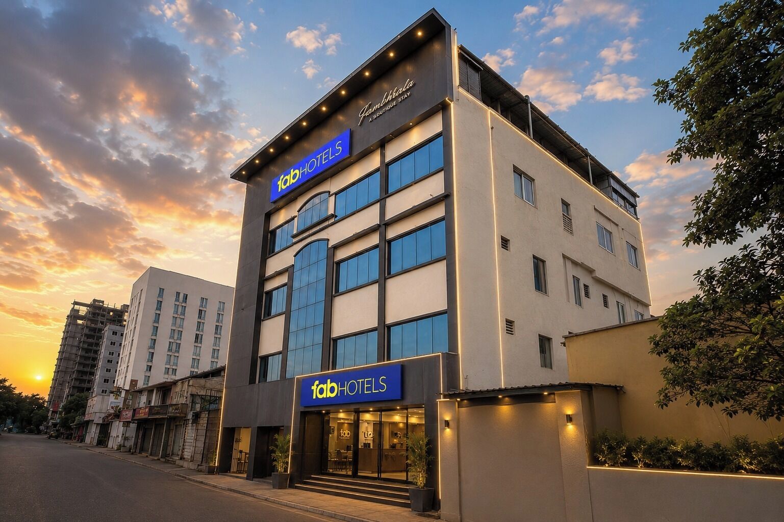 A multi-story building with a prominent 'fabHOTELS' sign, large windows, and a modern architectural design.