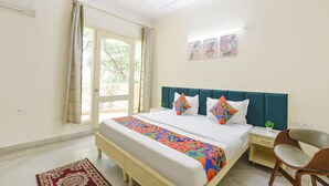 A bedroom with a bed, a desk, a chair, a ceiling fan, and a window with curtains.