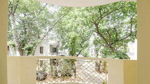 A room with a view of trees and a street.